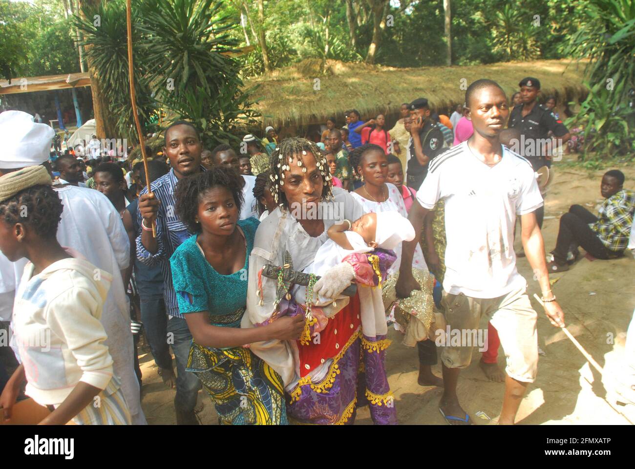 Osun Osogbo spirituel Ecstasy: Un prêtre emportant un enfant et sa mère à la déesse Osun pendant le festival Osun Osogbo. Banque D'Images