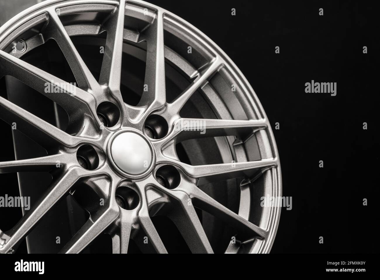 roues, rayons et jante en alliage légers et sportifs, gros plan sur un fond noir. Banque D'Images