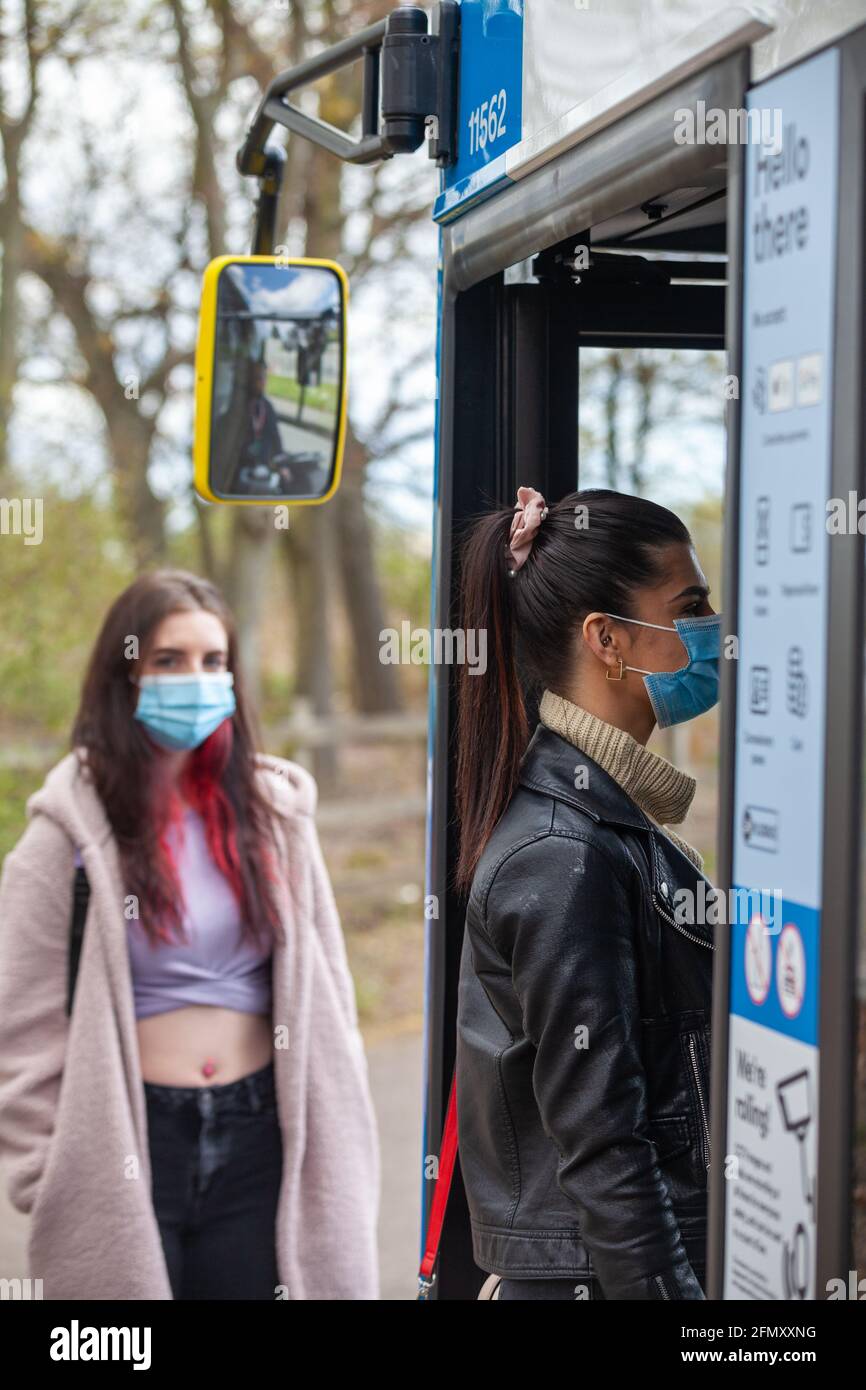 Deux jeunes femmes attendent à un arrêt de bus dans le rue Banque D'Images