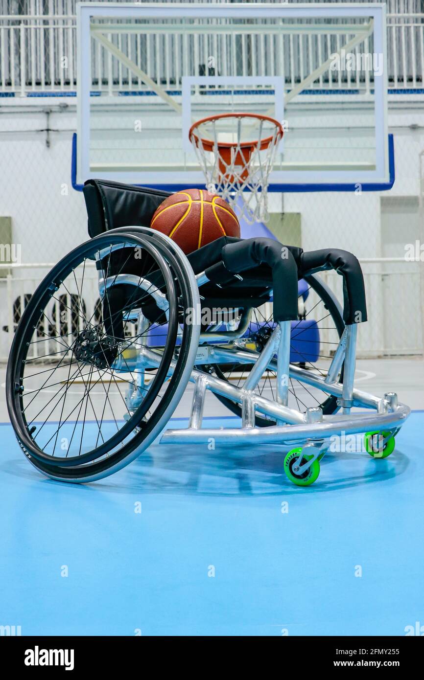Fauteuil roulant pour les joueurs de basket-ball paralympique, avec un  ballon de jeu sur la chaise et au fond de la table avec le panier de basket-ball  Photo Stock - Alamy