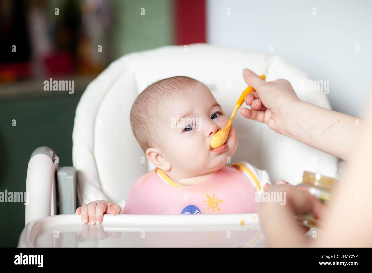 mère nourrissant sa petite fille avec une cuillère. Bébé mangeant Banque D'Images