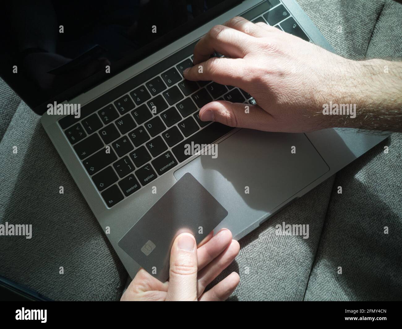 Achats en ligne. Un homme travaille sur un ordinateur portable et paie avec une carte de crédit Banque D'Images