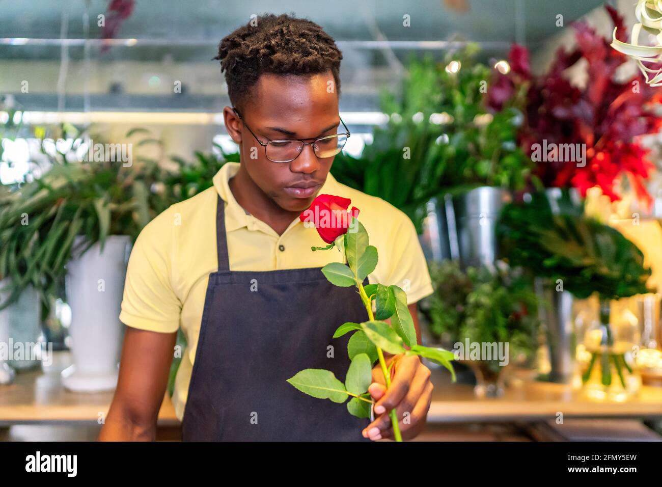 un jeune entrepreneur africain sent les fleurs de son entreprise Banque D'Images