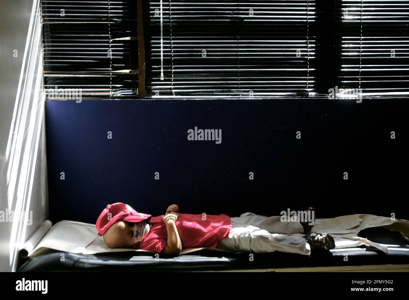 Venezuela-Maracaibo-29/11/2011-un enfant atteint d'un cancer dort sur un gourney en attendant son examen médical. © JOSE ISAAC BULA URRUTIA Banque D'Images