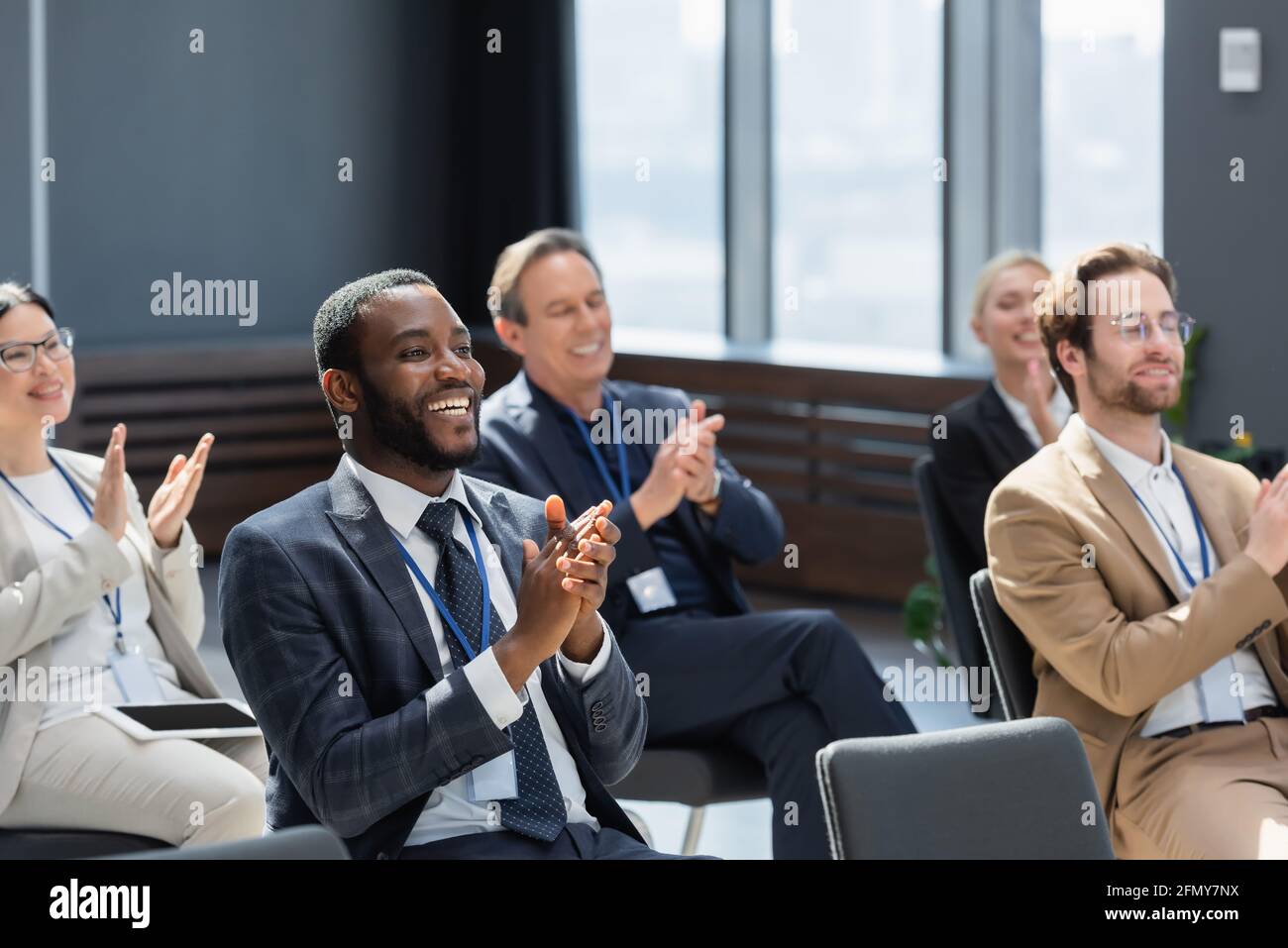 un homme d'affaires afro-américain applaudit aux participants multiethniques pendant le séminaire Banque D'Images