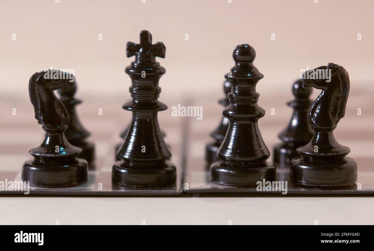 Roi et reine dans les échecs avec l'armée de pion isolée sur un fond blanc. Photographie macro Banque D'Images