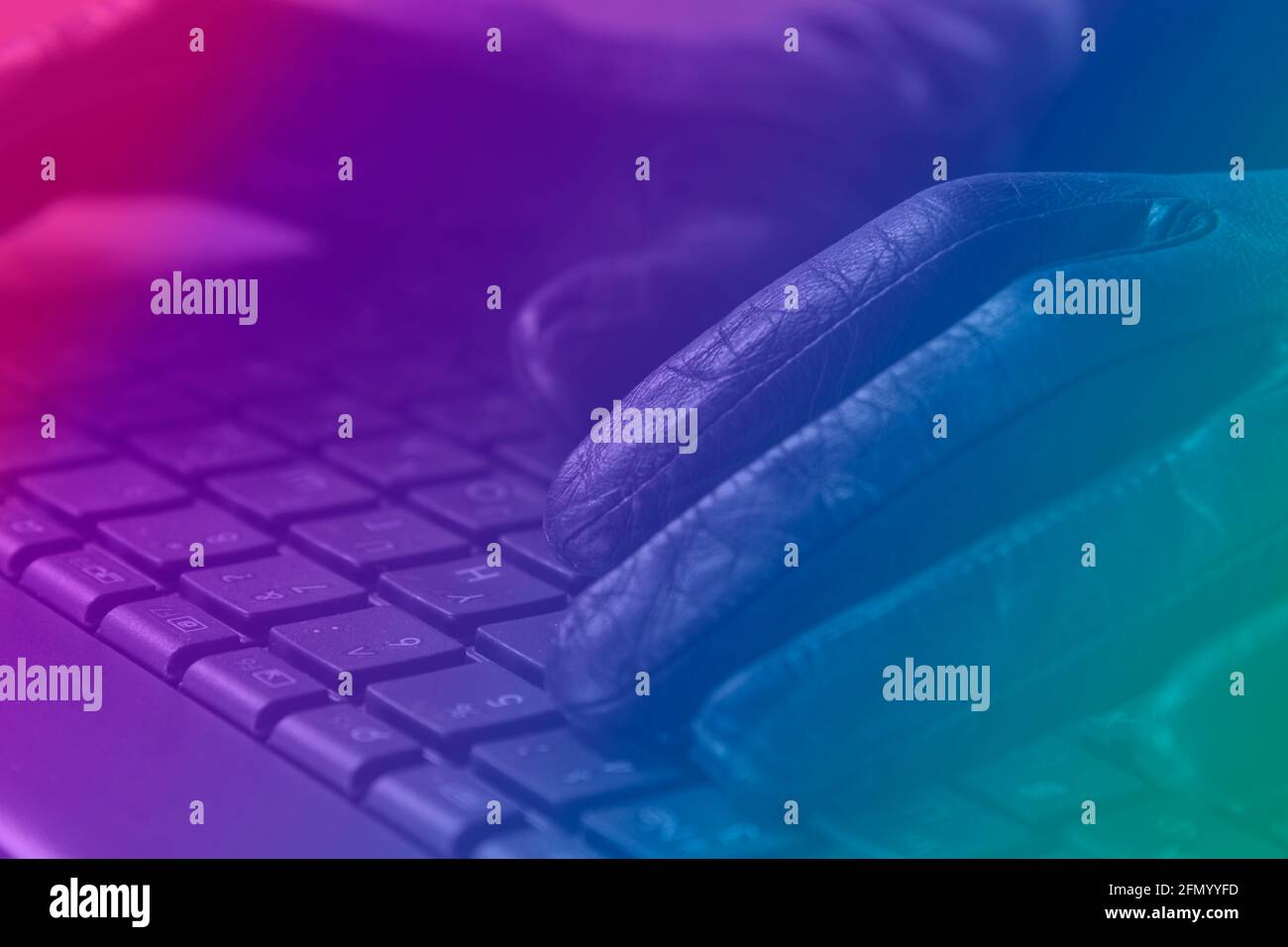 Cybercriminel, gants sur clavier d'ordinateur portable, ton photo avec néon. Banque D'Images