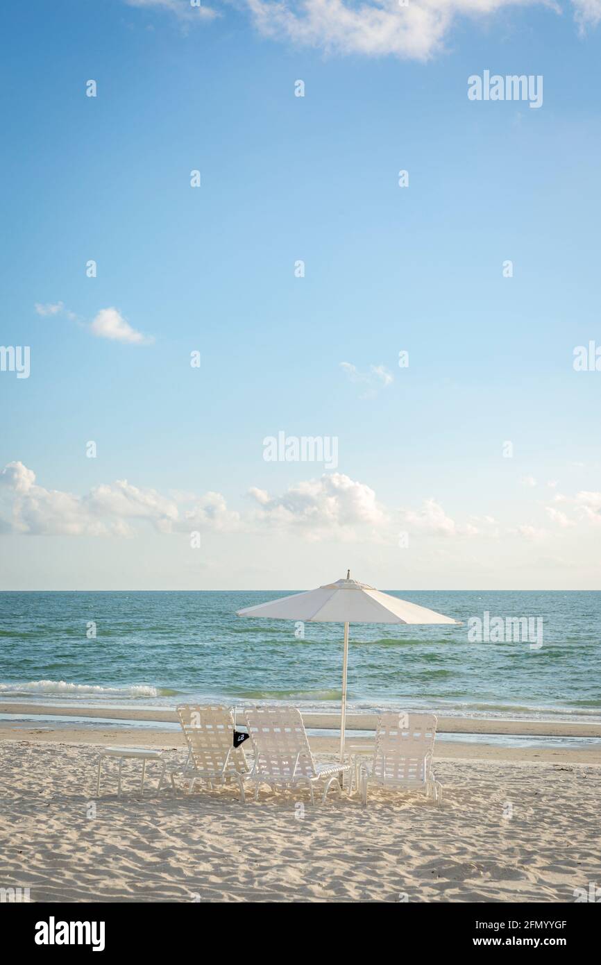 Chaises de plage et parasol surplombant le golfe du Mexique, Naples, Floride, États-Unis Banque D'Images