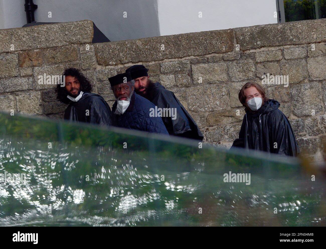 Penzance, Royaume-Uni. 12 mai 2021. Cornwall Royaume-Uni, St Michaels Mount, House of Dragon. Beaucoup de la fonte sans masques faciaux. Les acteurs reviennent de l'île en traversant un demi-kilomètre de mer ouverte enveloppée dans des capes étanches pour protéger les costumes coûteux. Une excursion en bateau agitée depuis le tournage sur l'île de St Michaels Mount jusqu'au mur du port de Marazion. 12 avril 2021. Crédit : Robert Taylor/Alay Live News Banque D'Images