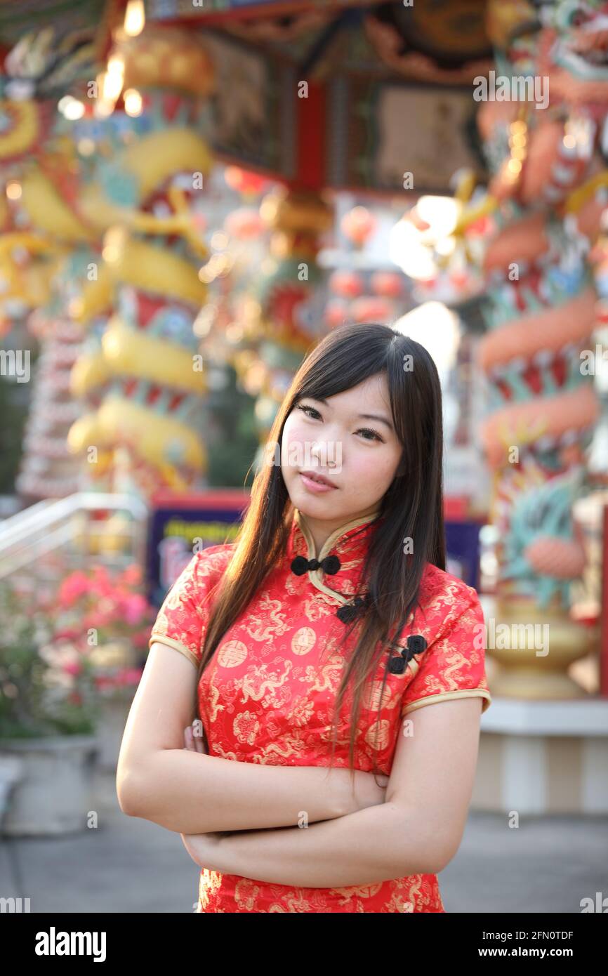 la femme de beauté porte le cheongsam rouge regardant et sourire en chinois nouvelle année Banque D'Images