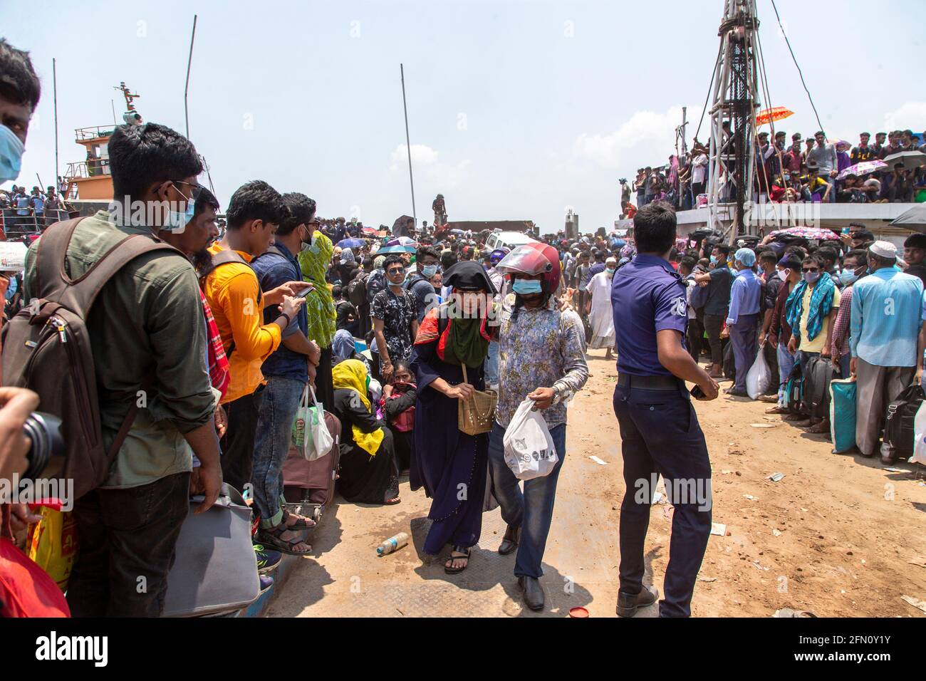 Des milliers de femmes et d'enfants attendent de monter à bord du ferry Shah Paran à Shimulia Ghat pour célébrer l'Eid malgré l'épidémie. Dans le soleil brûlant Banque D'Images