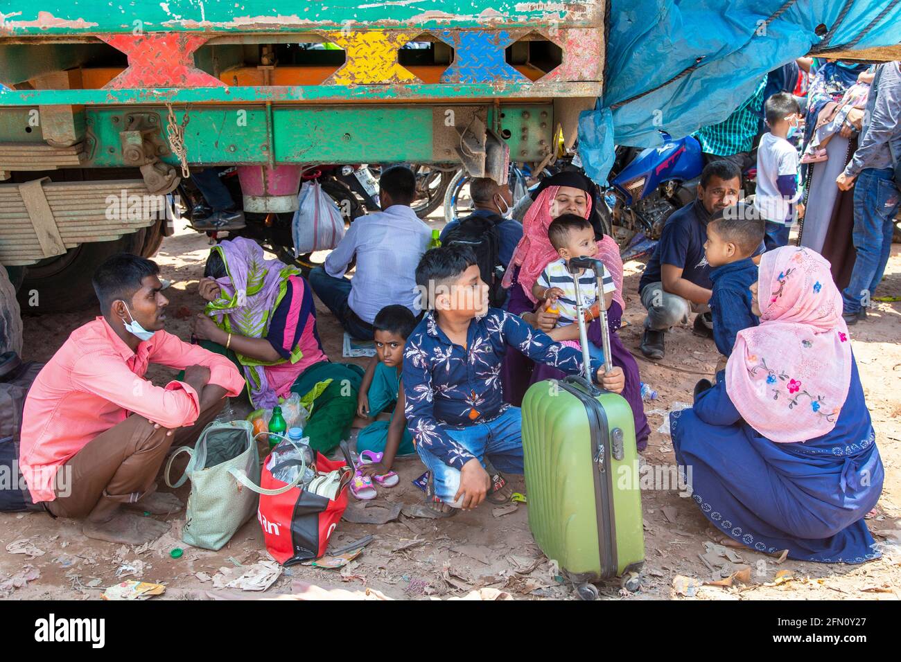 Des milliers de femmes et d'enfants attendent le ferry de Shimulia Ghat pour célébrer l'Eid malgré l'épidémie. Pour se protéger du scorc Banque D'Images