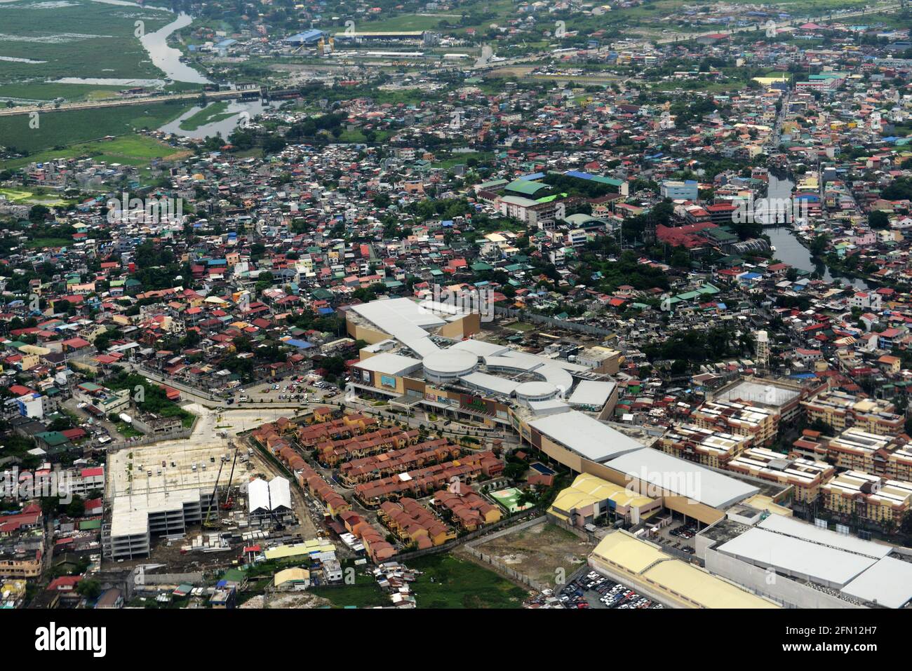 Vue aérienne d'un centre commercial avec un complexe résidentiel moderne dans le nord de la région métropolitaine de Manille, Philippines. Banque D'Images