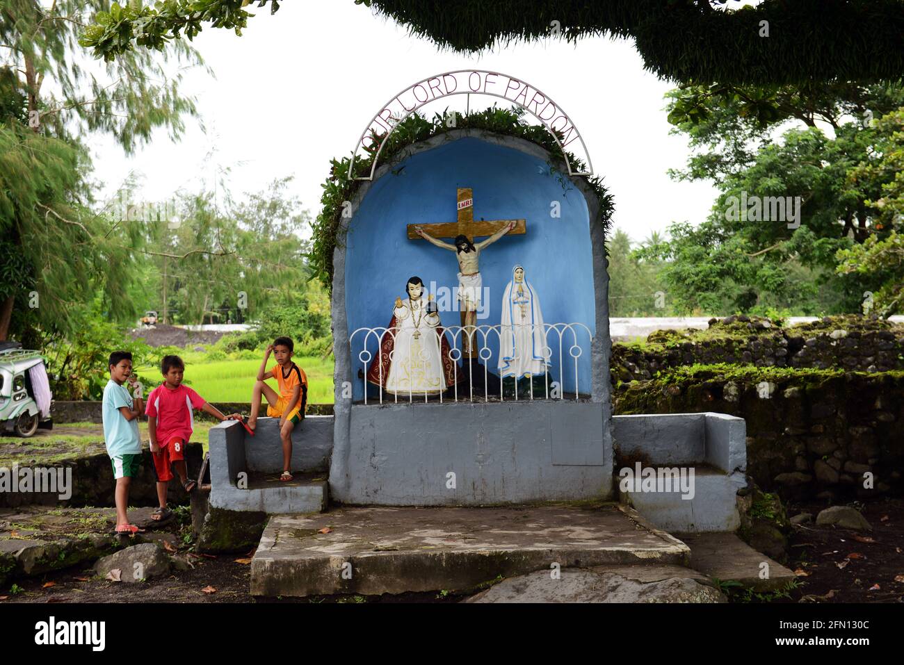 Garçons philippins se tenant à côté d'une petite chapelle près des ruines de Cagsawa à Bicol, Philippines. Banque D'Images