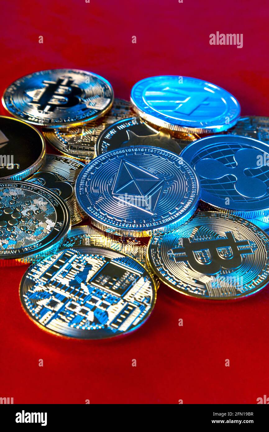 Pile de pièces de jetons crypto-monnaies avec éthélium (éther) en évidence sur fond rouge Banque D'Images
