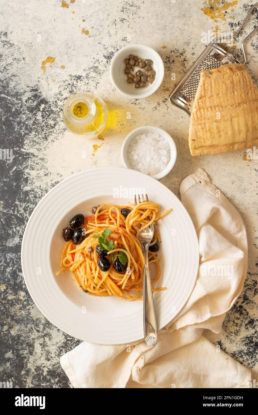 Pâtes puttanesca : pâtes italiennes célèbres avec sauce aux olives noires et aux tomates rouges Banque D'Images