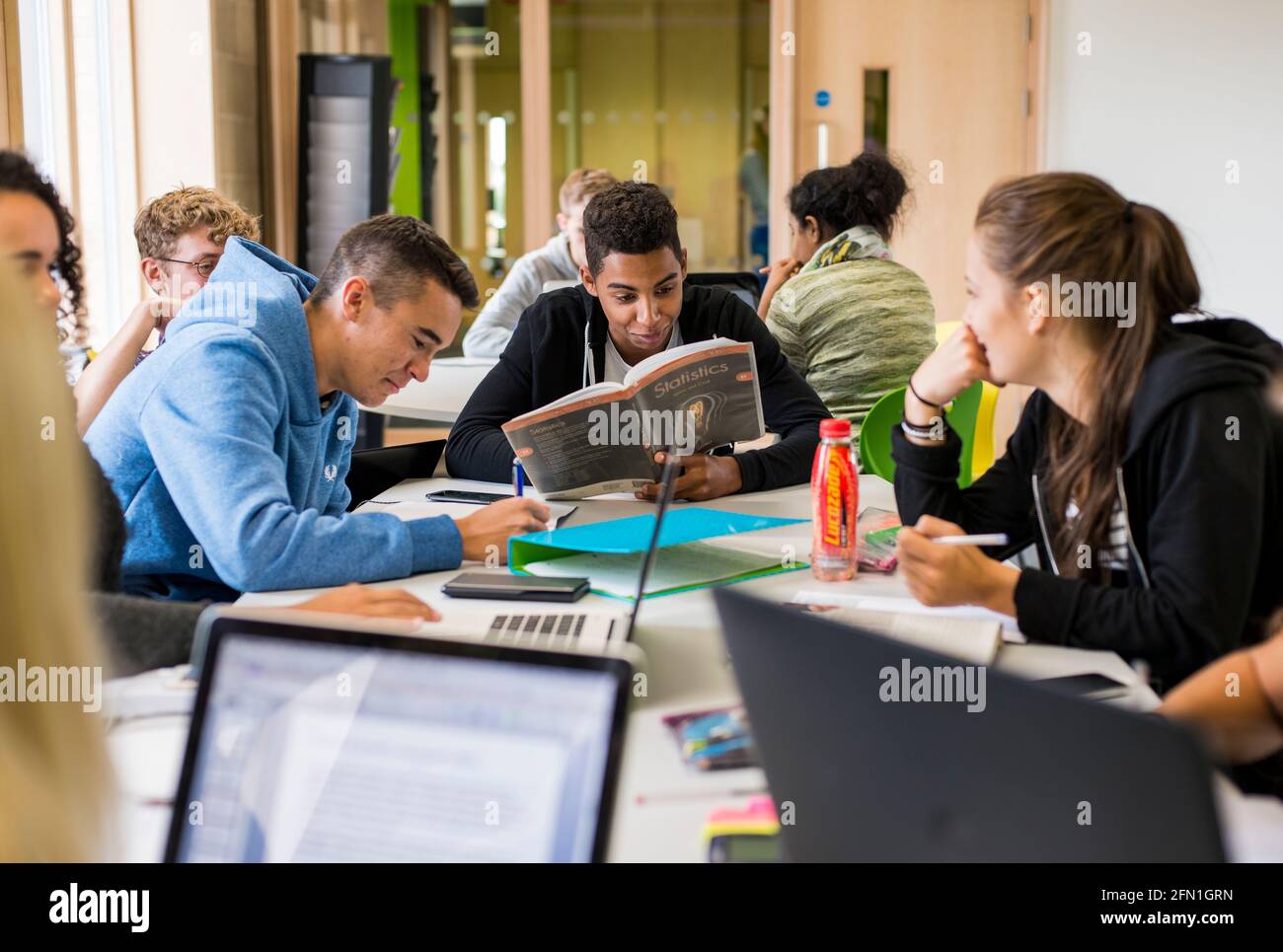 Les élèves multiculturels de la sixième forme, les jeunes dans l'éducation, les adolescents regardant l'ordinateur portable de la sixième forme, les étudiants travaillant à l'ordinateur portable Banque D'Images