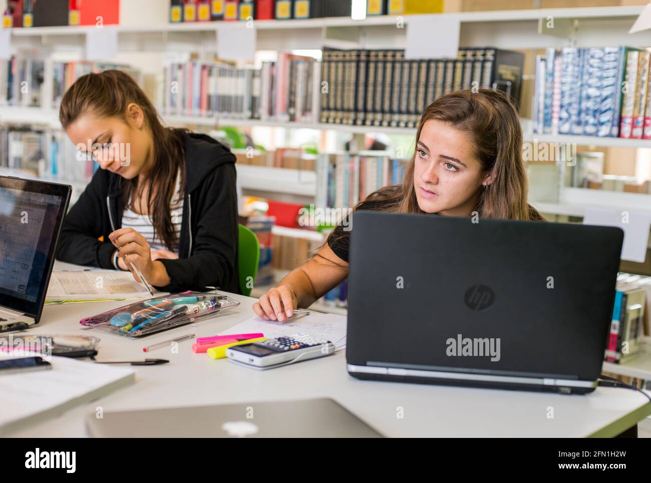 Élèves de la sixième forme, jeunes femmes dans l'éducation, adolescents regardant l'ordinateur portable de la sixième forme, étudiantes travaillant à l'ordinateur portable Banque D'Images