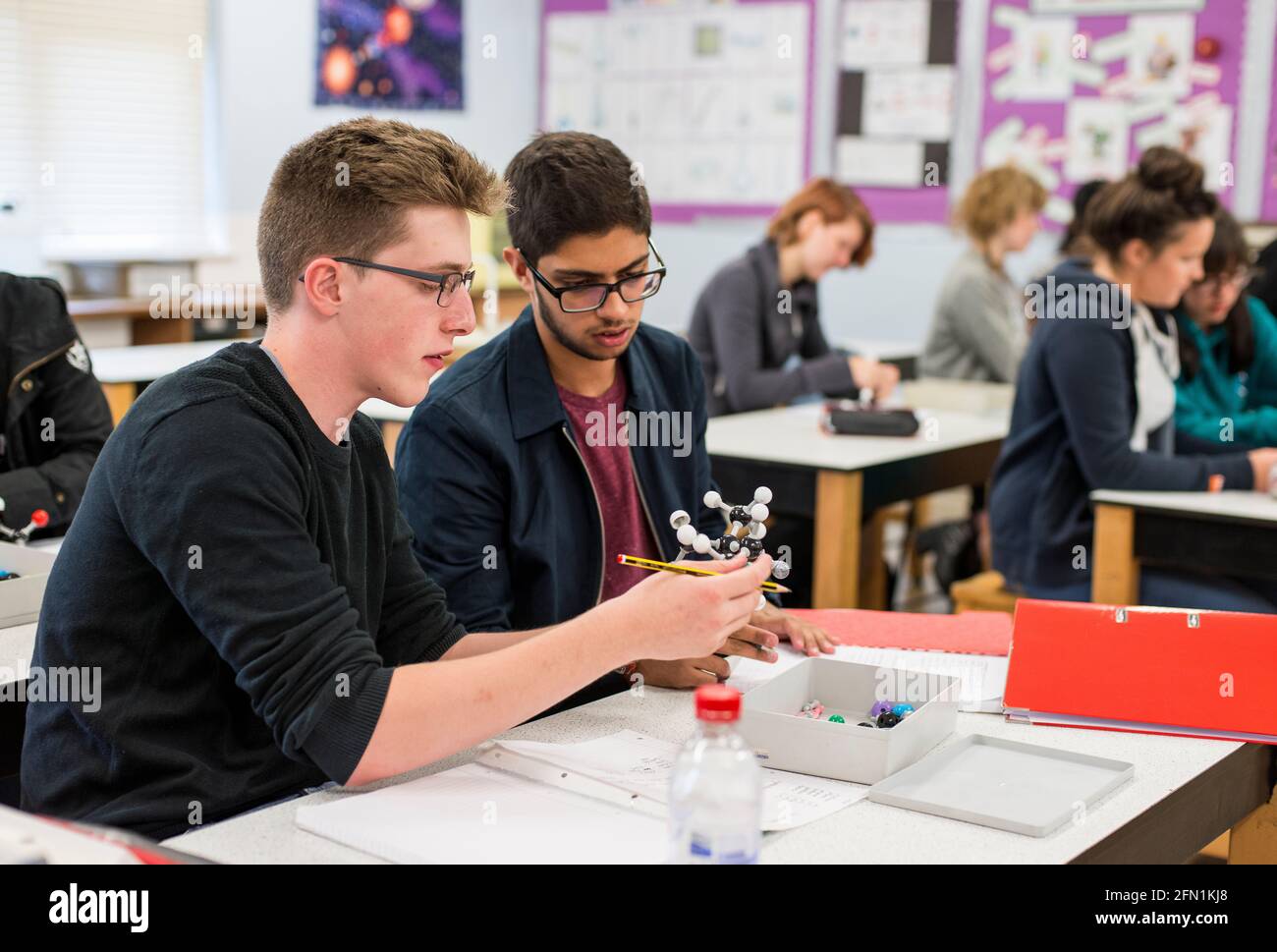Élèves de la sixième forme, jeunes dans l'éducation, deux adolescents collaborant aux écrans, 2 jeunes hommes de la 6e forme travaillant ensemble dans la leçon de chimie Banque D'Images