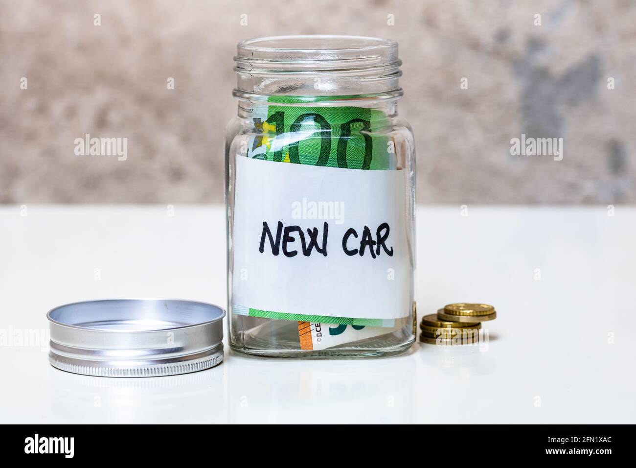 Composition avec billets d'argent d'économie dans un pot en verre avec envoyer un sms à une nouvelle voiture Banque D'Images