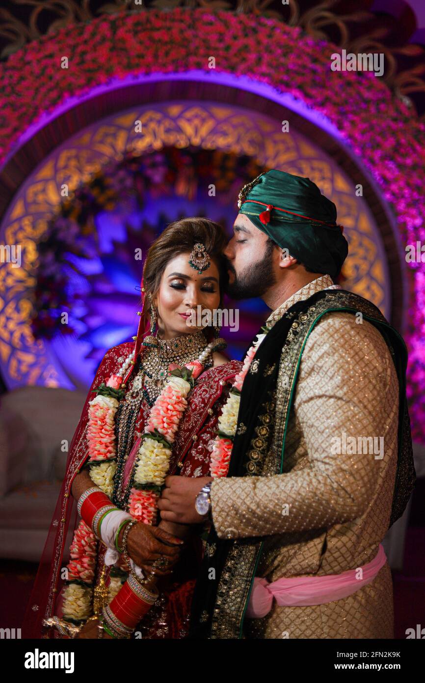 magnifique superbe mariée indienne et robe traditionnelle de marié posent sur leur cérémonie de mariage. Banque D'Images