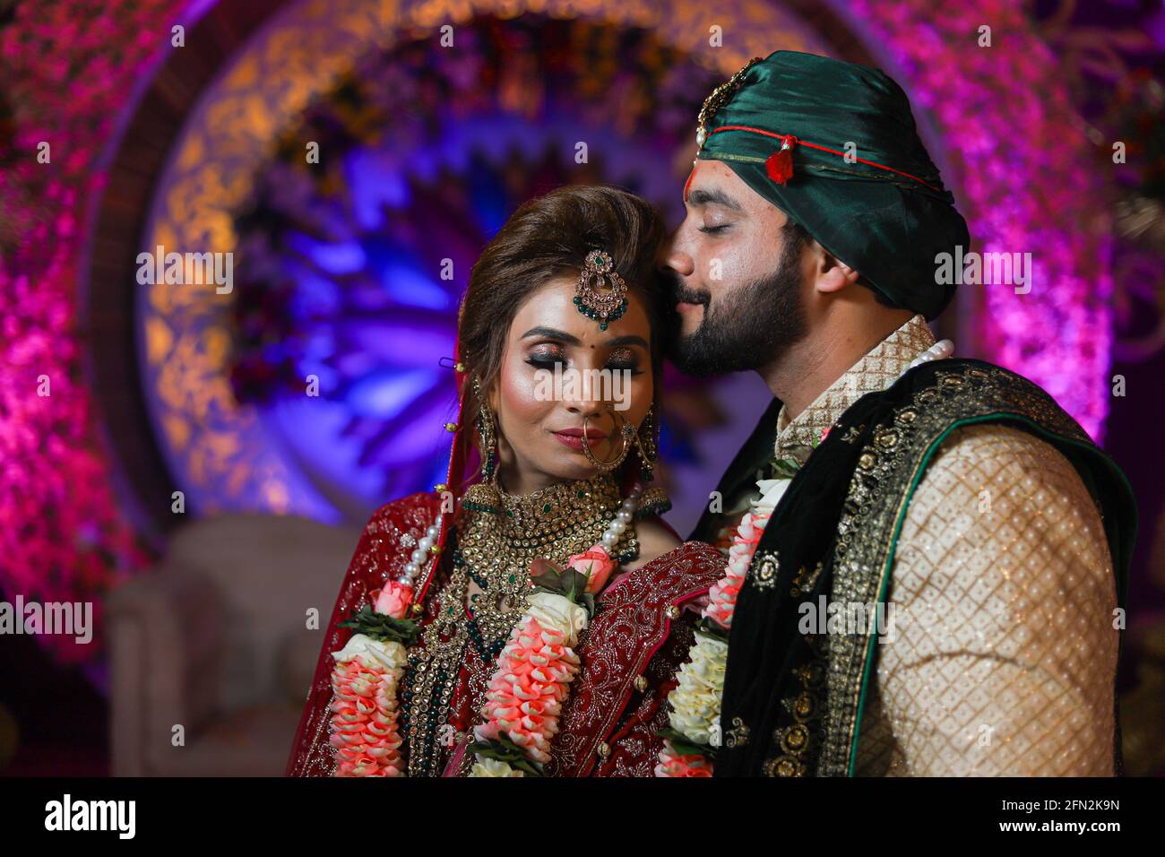 magnifique superbe mariée indienne et robe traditionnelle de marié posent sur leur cérémonie de mariage. Banque D'Images