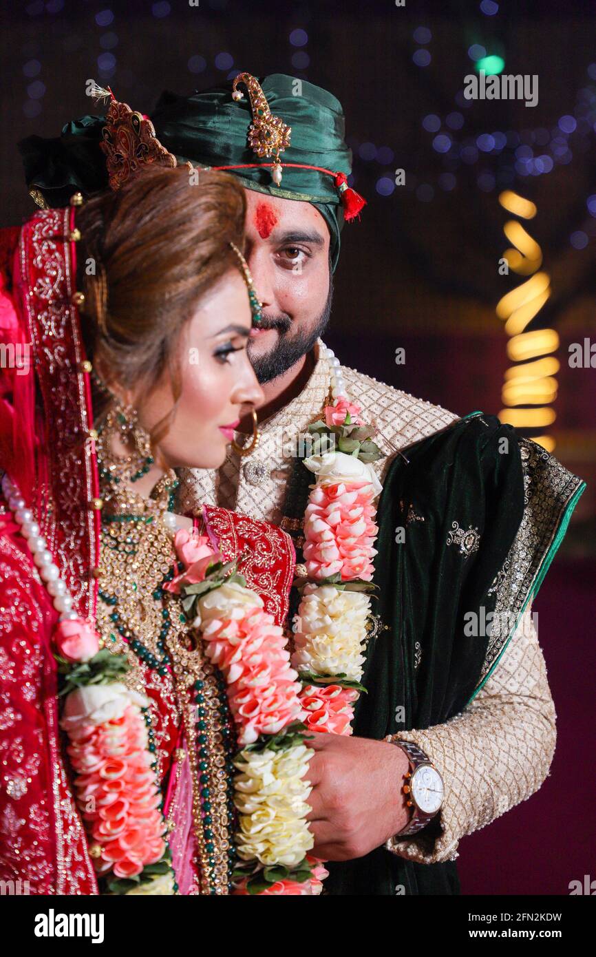 magnifique superbe mariée indienne et robe traditionnelle de marié posent sur leur cérémonie de mariage. Banque D'Images