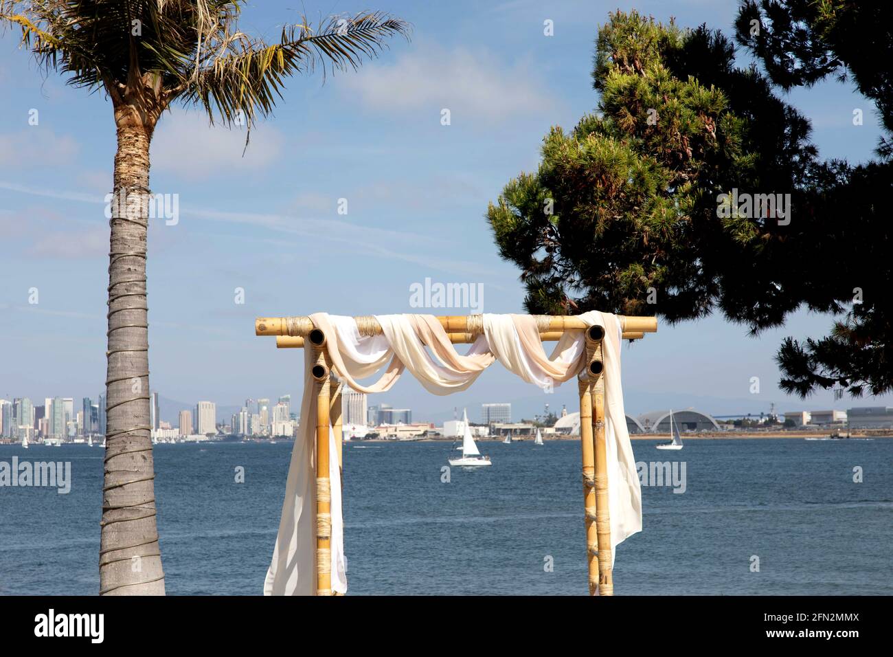 Arc de mariage en bois carré pour le mariage en extérieur de club de yacht de plage. Chaises blanches et arche décorée pour un mariage en bord de mer. Banque D'Images