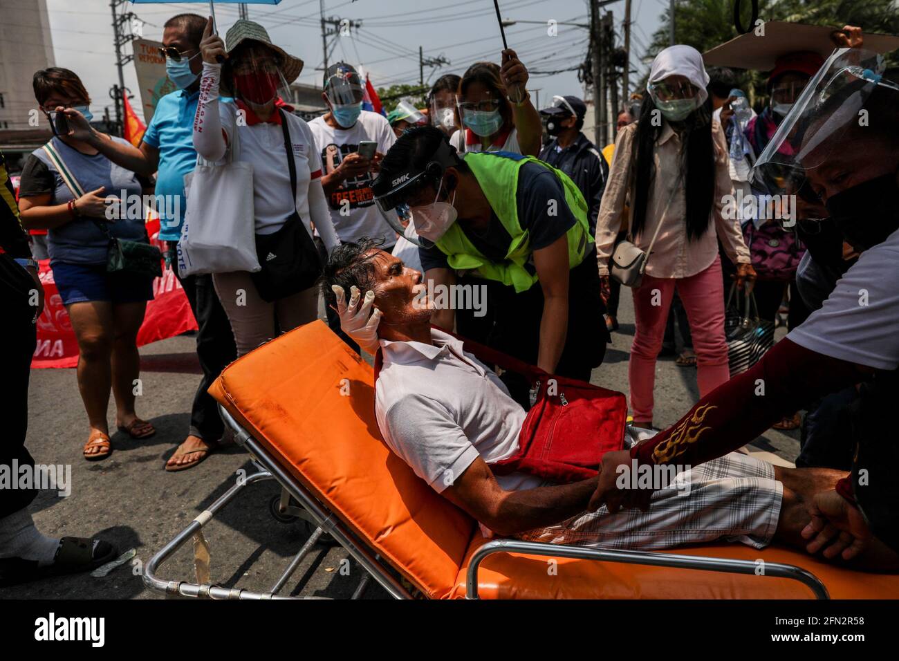 Les membres du Bureau de gestion de la réduction des risques de catastrophe de la ville de Quezon ou du QCDRRMO répondent à un manifestant qui s'est inconscient lors d'une protes à l'occasion de la Journée du travail à Quezon City. Divers groupes ont appelé à des droits et des avantages du travail adéquats, tels que l'augmentation du salaire minimum, l'aide financière et les tests de masse dus à la COVID-19. Metro Manille, Philippines. Banque D'Images