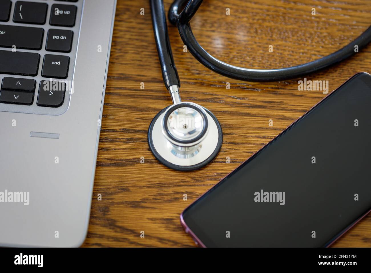 Télémédecine, conseil et diagnostic à distance, ordinateur portable, téléphone portable et stéthoscope sur le bureau Banque D'Images