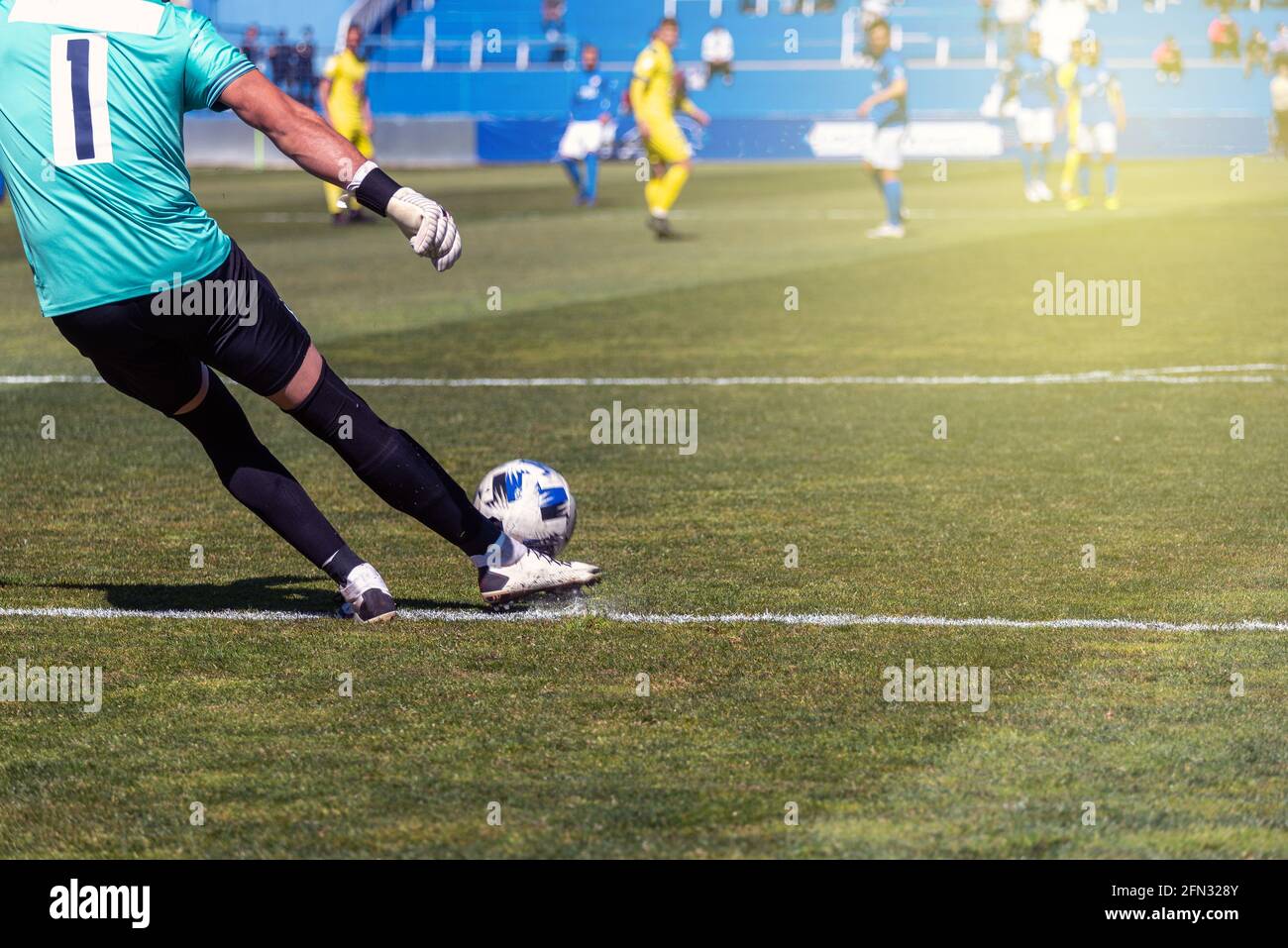 le joueur de football frappe le ballon avec sa jambe droite surface d'herbe naturelle Banque D'Images
