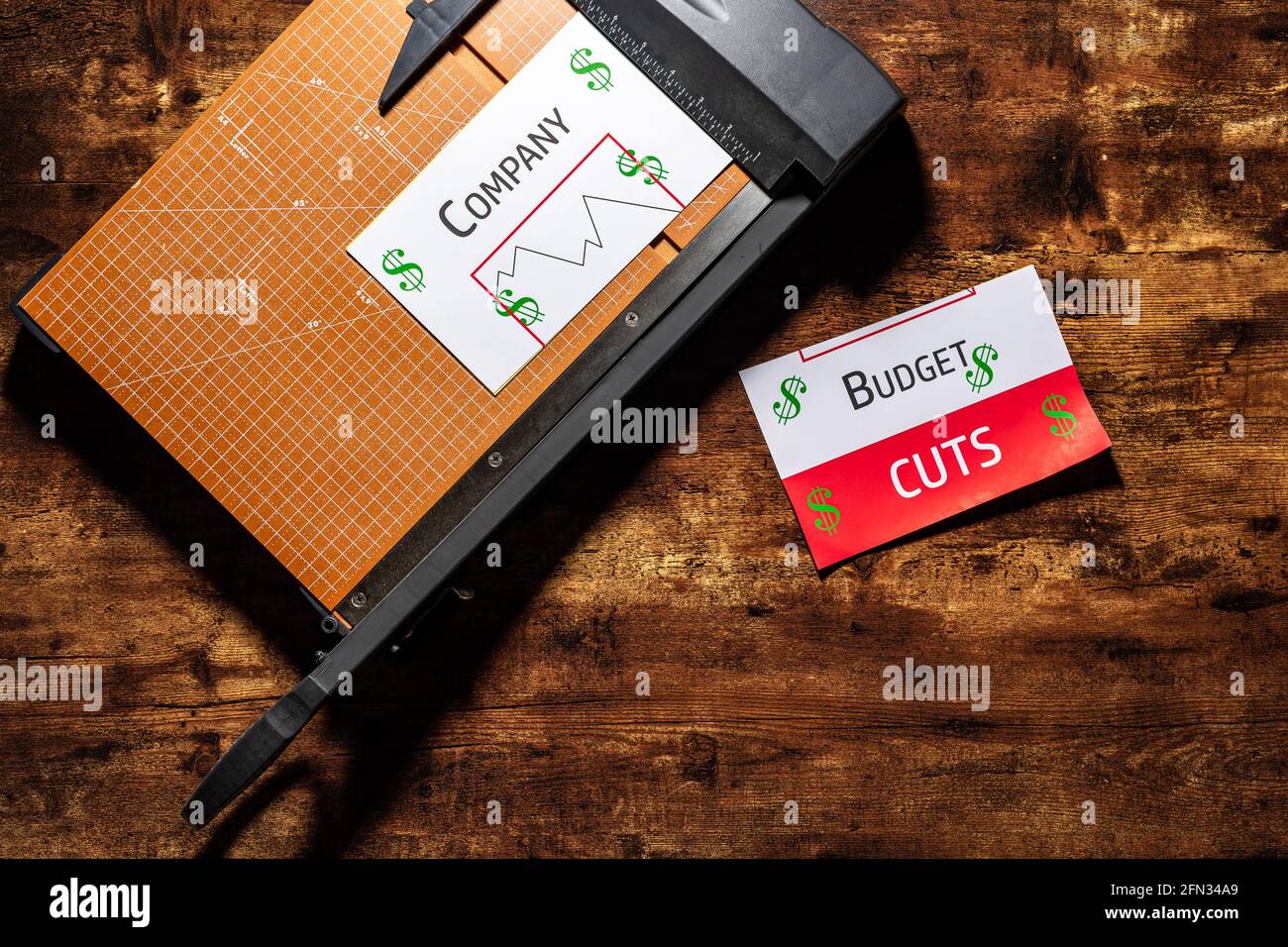 Photo de concept de budget coupé avec rapport de budget générique sur une planche à découper Banque D'Images