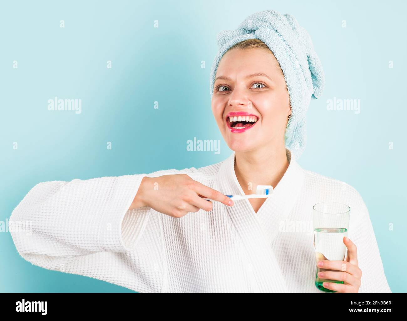 Femme souriante se brossant les dents dans la salle de bains. Fille avec brosse à dents. Hygiène dentaire. Soins buccaux. Procédure matinale. Banque D'Images