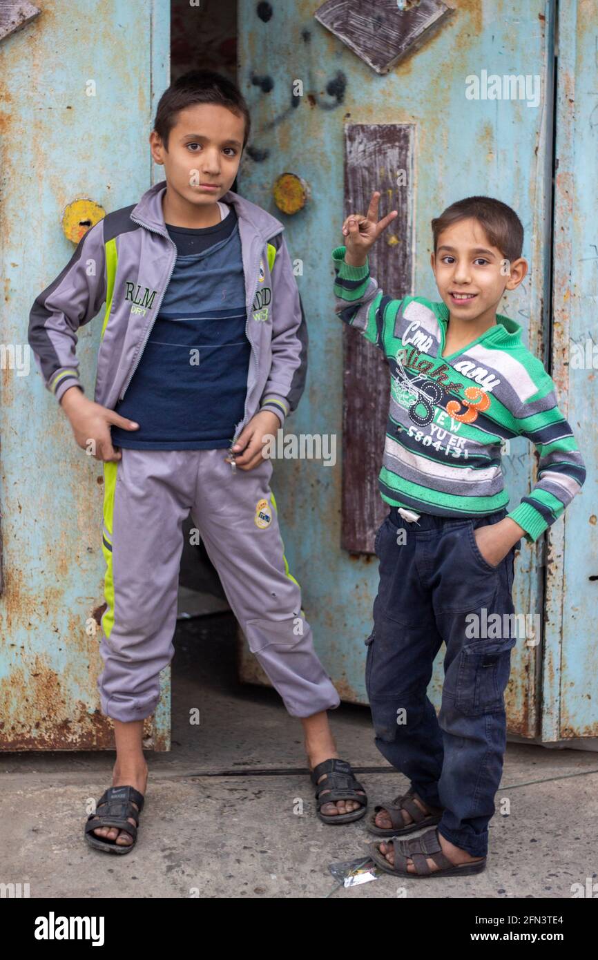 Deux garçons posent pour une photo pendant les premiers jours de l'opération de Mossoul dans le district d'Al Bakir à Mossoul est, en Irak. Banque D'Images