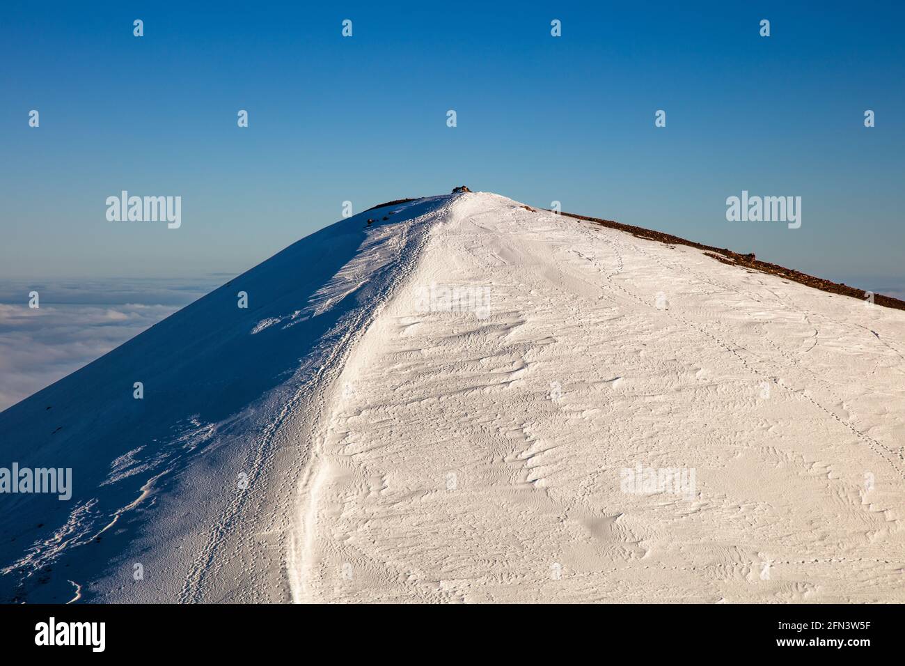 Le sommet enneigé de Mauna Kea, le plus grand volcan du bouclier du monde, et la plus haute montagne du monde, si mesurée à partir de sa base. Sur le Big I Banque D'Images