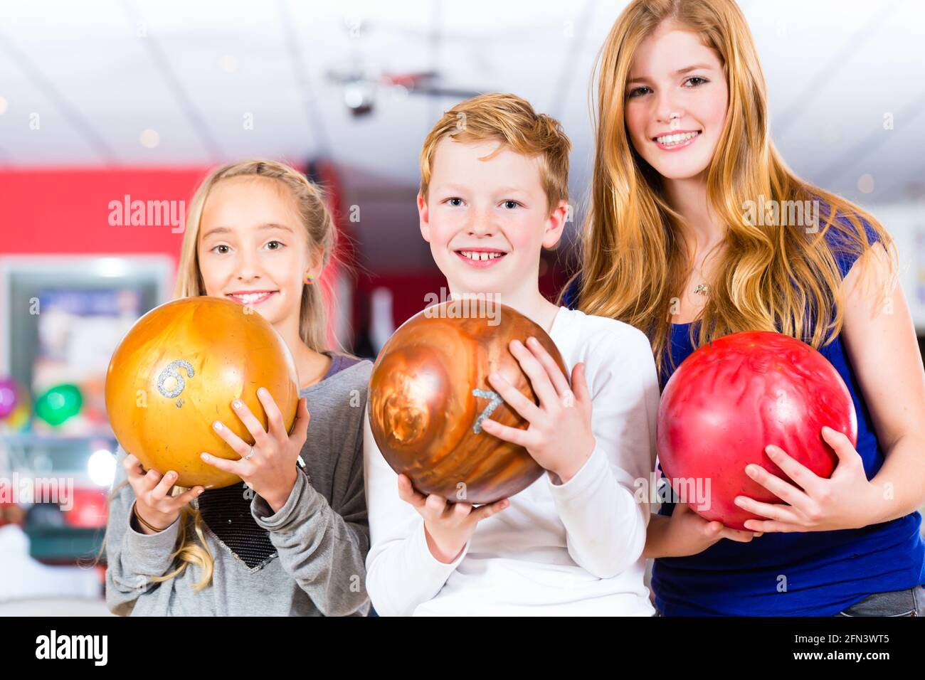 Les Amis des enfants jouer ensemble à centre de bowling Banque D'Images