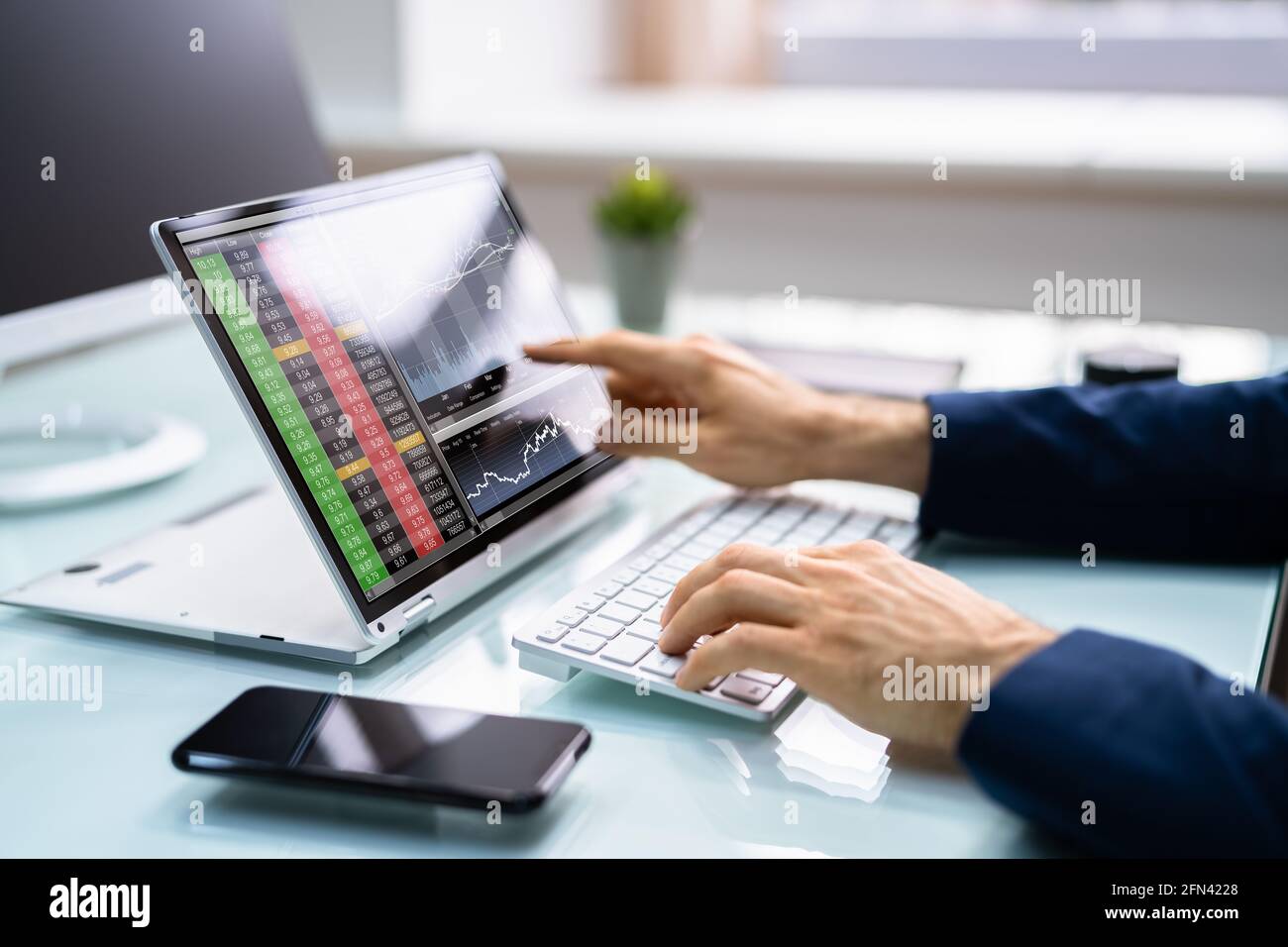 Courtier en Bourse qui échange sur un ordinateur portable convertible Banque D'Images