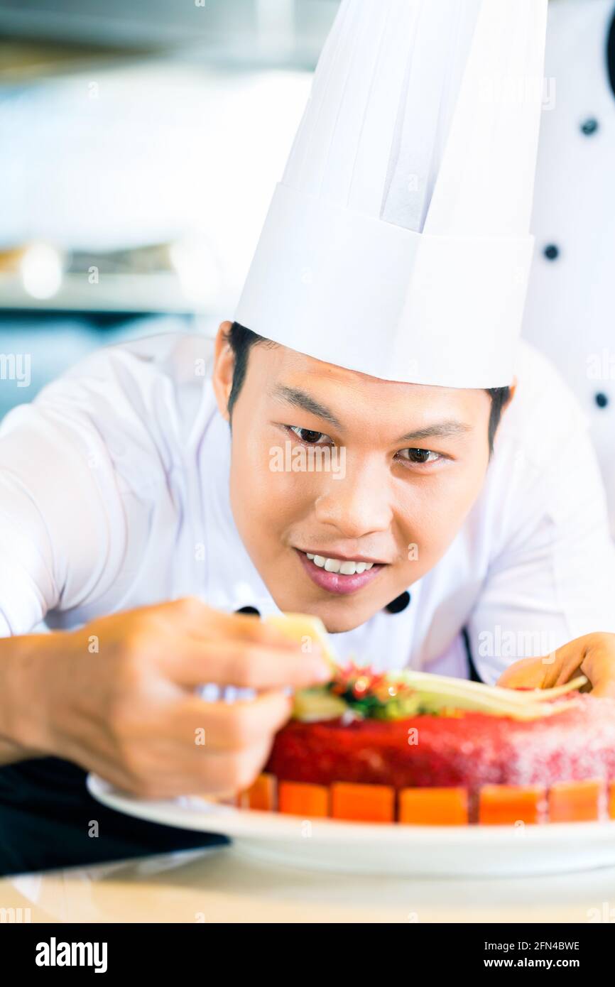 Portrait of Asian chef decorating cake Banque D'Images