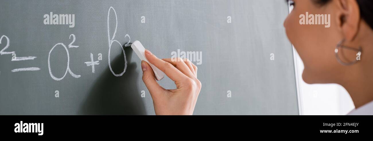 Vue rognée d'un professeur flou écrivant équation mathématique, bannière Banque D'Images