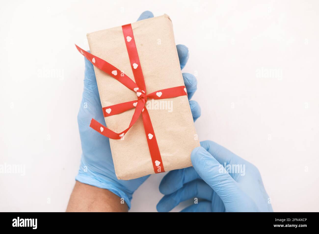 main de sexe masculin dans un gant médical bleu donne un cadeau. Banque D'Images