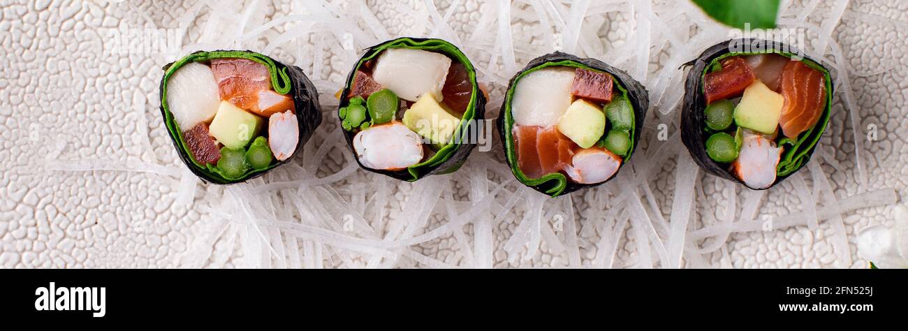 Vue de dessus d'un petit sushi japonais sain sans riz avec de la viande de crabe enveloppée de radis daikon Banque D'Images