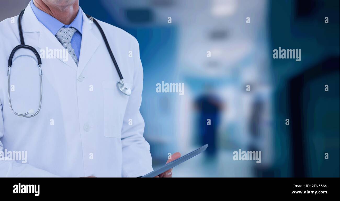 Composition de la section médiane du médecin masculin dans une tenue de blouse de laboratoire planchette à pince sur l'hôpital hors foyer Banque D'Images