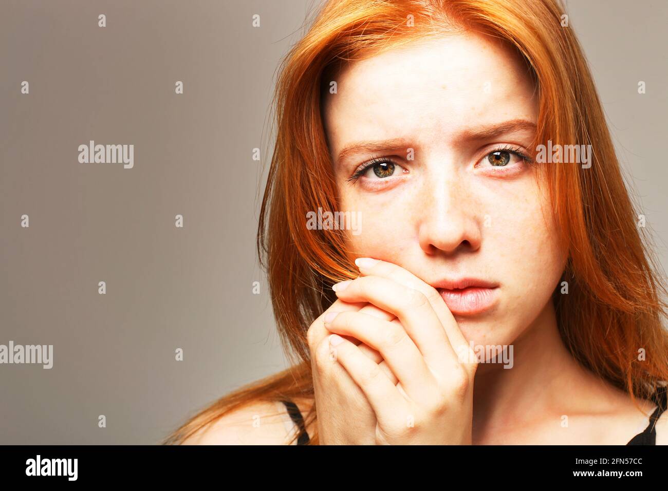 Belle fragile jeune femme à tête rouge dans l'obscurité. Triste fille effrayée peur de l'abus. Comportement non verbal, langage corporel. Cheveux rouges femme regarde s Banque D'Images