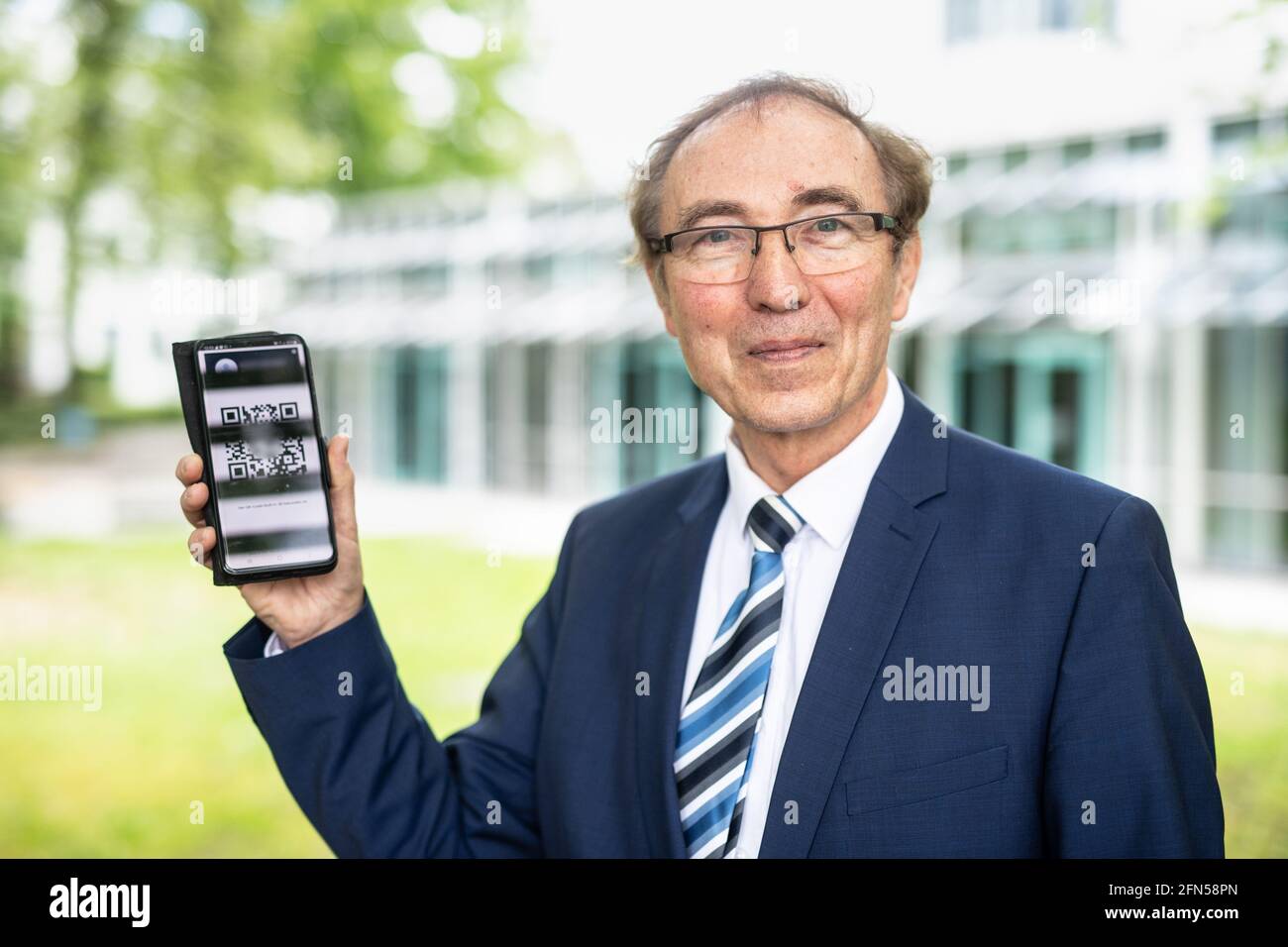 Ebersberg, Allemagne. 14 mai 2021. Martin Behmann, directeur général du prestataire de services Alive-Service GmbH et développeur d'un concept de passeport de vaccination numérique, présente un code QR pour vérifier le certificat de vaccination Covid-19 sur l'interface de son concept de passeport de vaccination numérique « Passeport de santé numérique Alive » au centre de vaccination d'Ebersberg sur son smartphone. Au cours de la visite, le ministre apprend l'expérience du centre de vaccination avec le concept de passeport numérique de vaccination « carte de santé numérique vivante ». Credit: Matthias balk/dpa/Alay Live News Banque D'Images