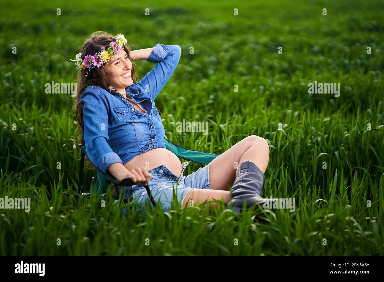 Bonne jeune femme enceinte dans un champ de blé dans le campagne Banque D'Images