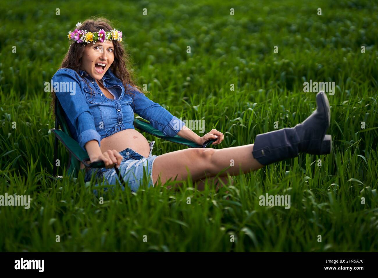 Bonne jeune femme enceinte dans un champ de blé dans le campagne Banque D'Images