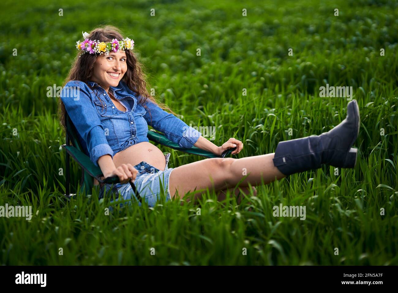 Bonne jeune femme enceinte dans un champ de blé dans le campagne Banque D'Images