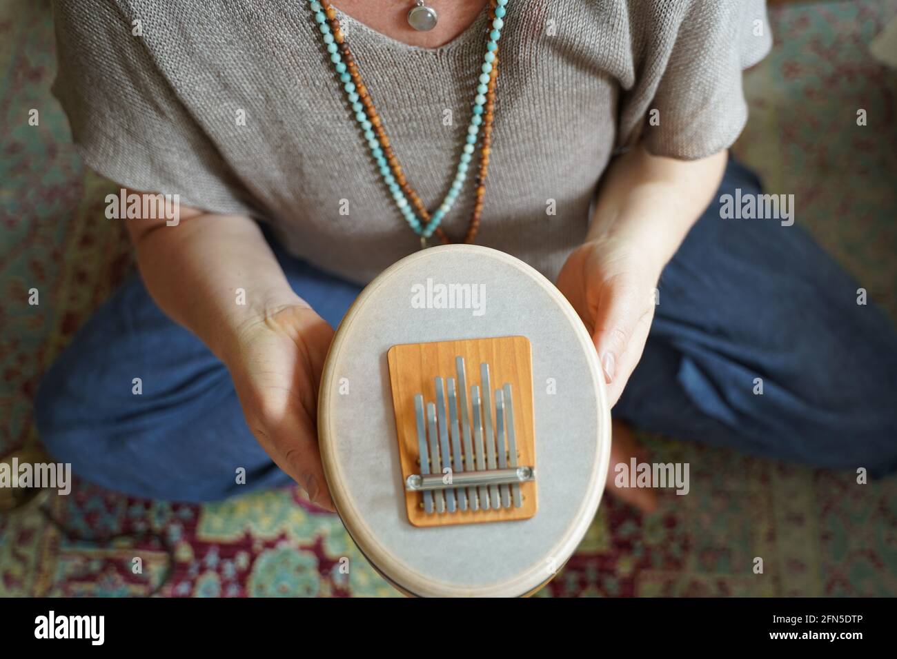 Femme tenant et jouant un instrument de guérison sonore Sansula pour la thérapie de guérison sonore Banque D'Images