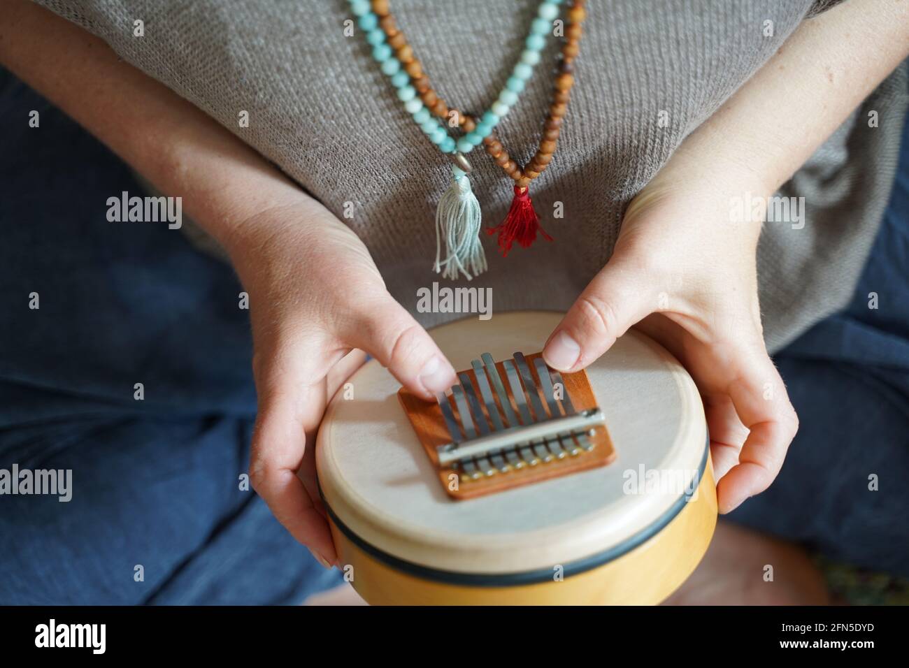 Femme tenant et jouant un instrument de guérison sonore Sansula pour la thérapie de guérison sonore Banque D'Images