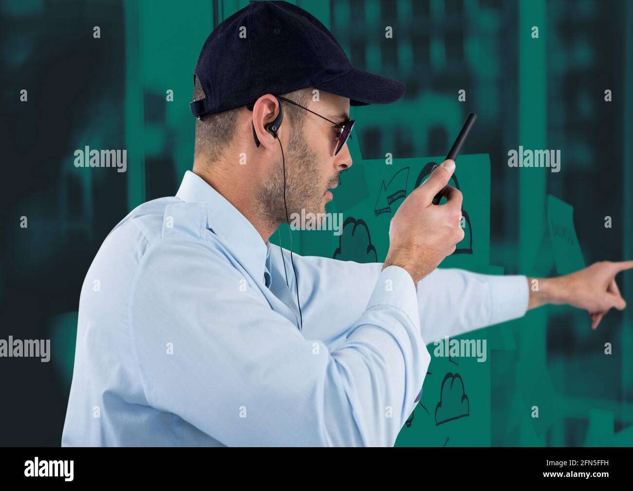 Composition d'un agent de sécurité mâle utilisant la main de main de talkie walkie sur fond vert Banque D'Images